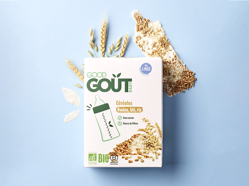 Boîte de céréales bio pour bébé de la marque Good Goût, saveur avoine, blé et riz, posée sur un fond bleu avec des grains de céréales et des épis en décoration.